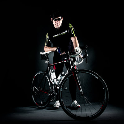 bicycle rider wearing sport clothes and sunglasses portrait in a dark studio looking strong 