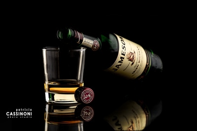 bottle of Jameson shoot in studio over a reflective surface with beautiful lighting 